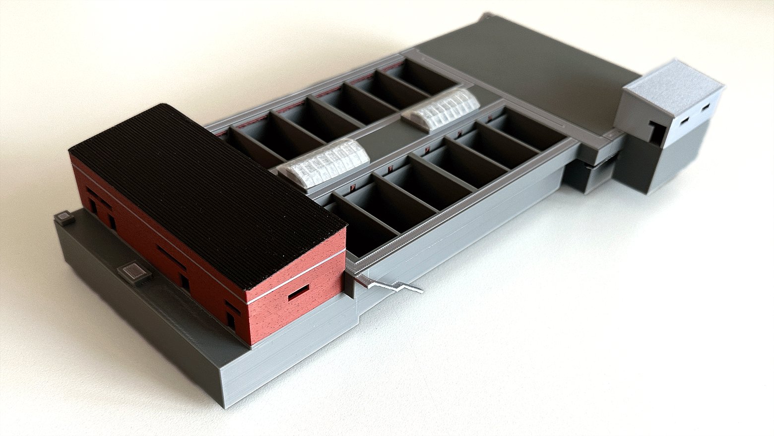 A 3D printed building site model with the roof lifted off, printed in grey and red filament with visible layer lines