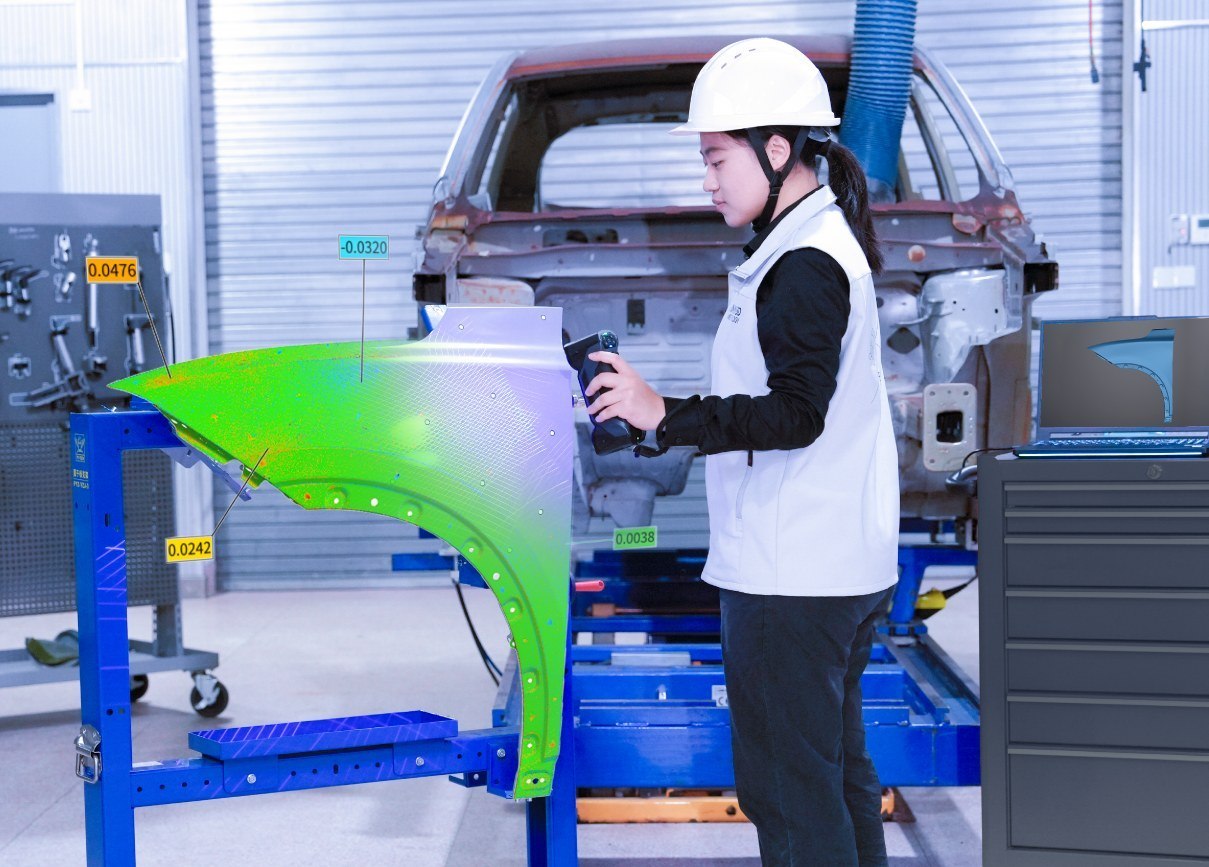 Operator scanning a component in place on the workshop floor with a handheld 3D scanner
