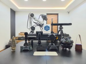 The Trinventor Solution 3D scanner range on the showroom table in Kuala Lumpur — robot-mounted, tracked, handheld and desktop scanners