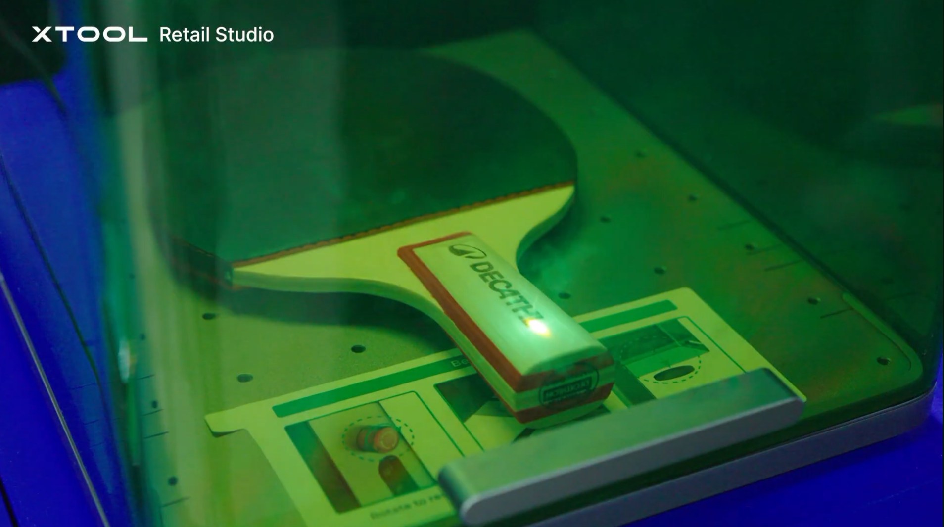 A laser marking a personalised paddle inside the xTool machine, held in its positioning jig