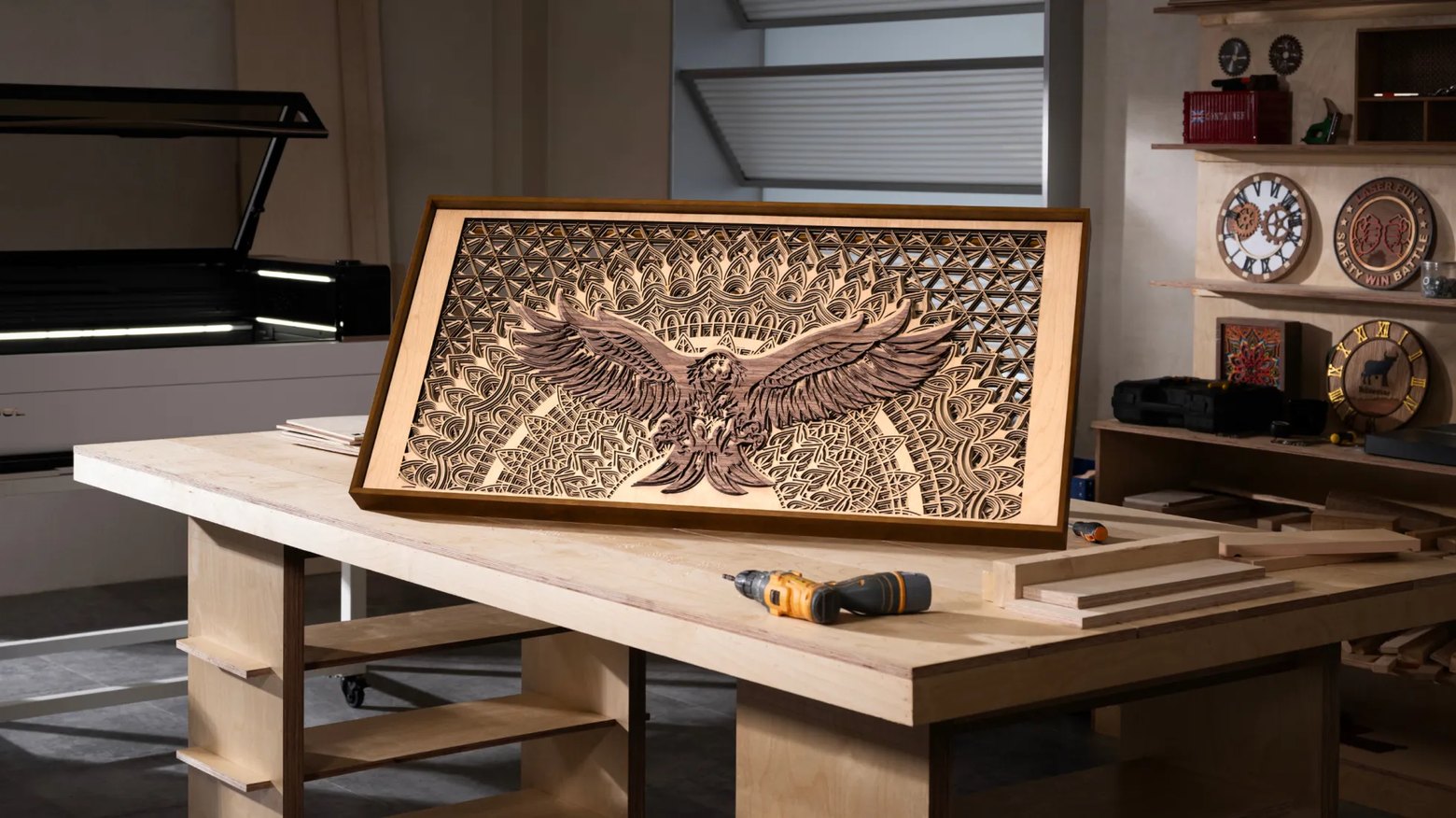 Intricate layered wood artwork cut on a CO2 laser, displayed on a workshop bench