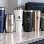 Six personalised tumblers in assorted finishes, each engraved with a different corporate logo