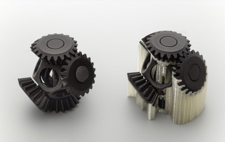 A printed gear assembly shown with soluble supports still in place and after removal