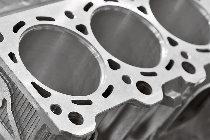 Close-up of a machined engine block showing bores, water passages and mounting faces