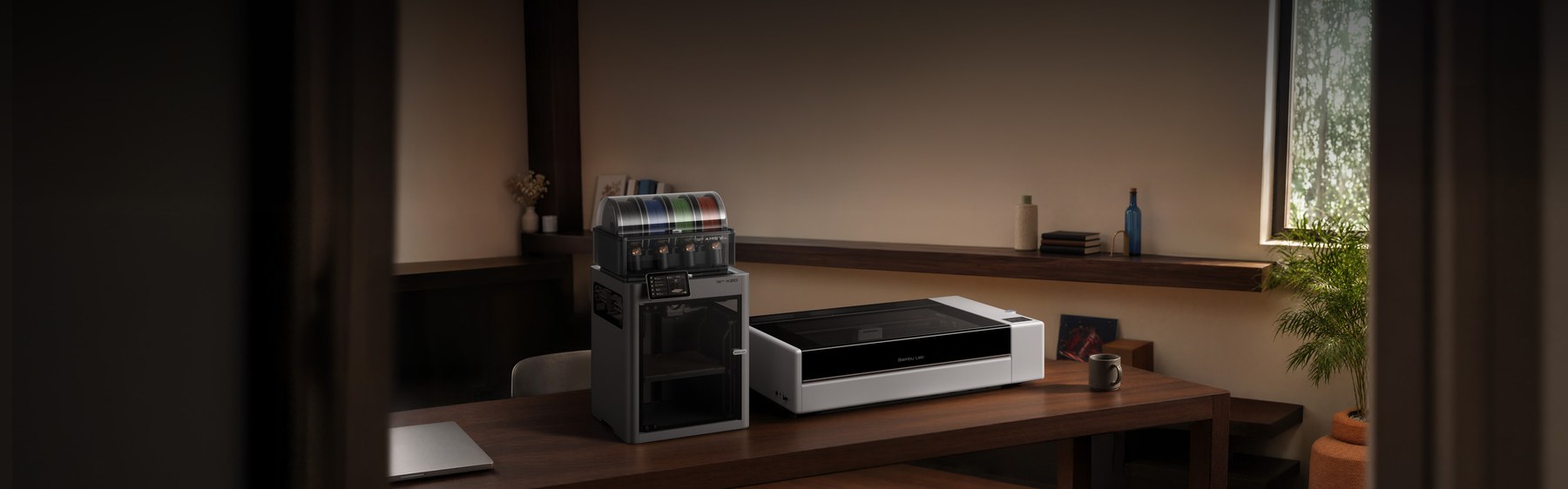 Bambu Lab R1 laser cutter in a maker workshop alongside a Bambu Lab 3D printer