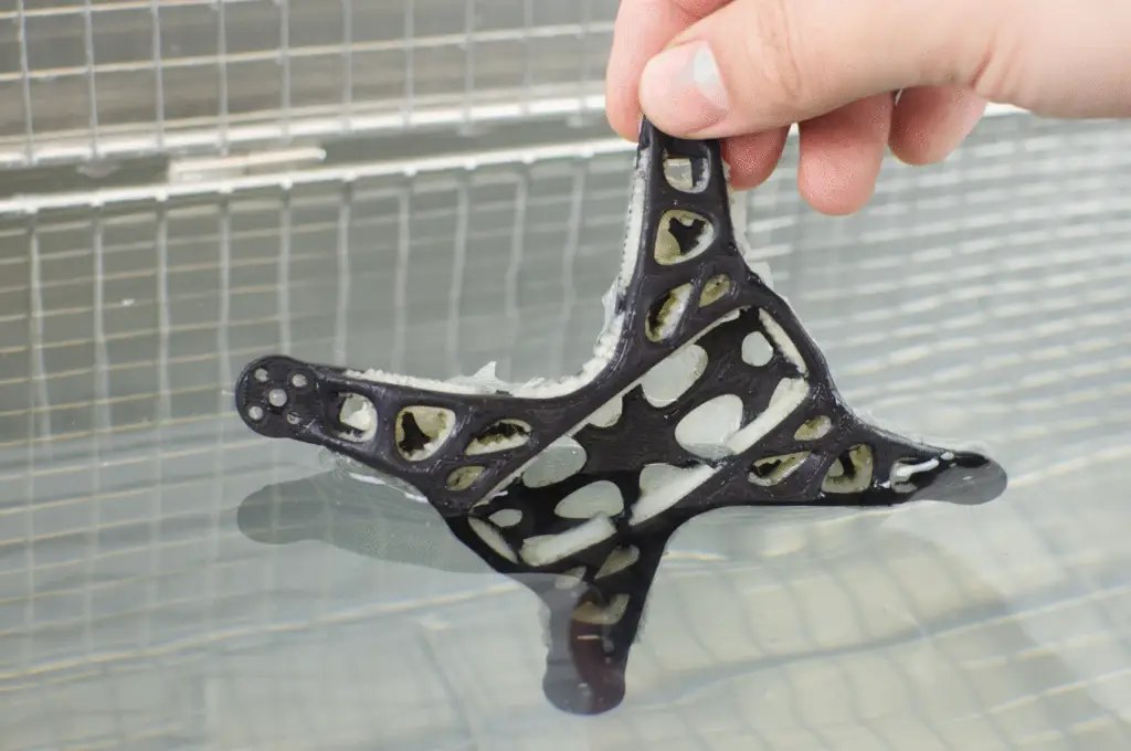 A printed part being rinsed in water as soluble support material dissolves away