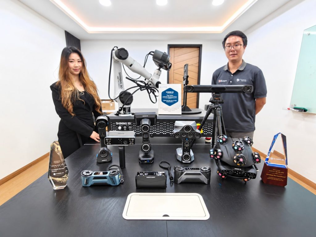 The full Shining 3D scanner range on the Trinventor Solution showroom table in Kuala Lumpur — robot-mounted, tracked, desktop and handheld scanners