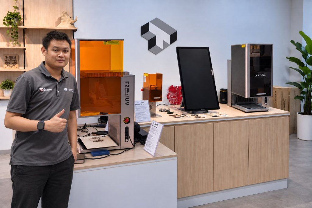 A Trinventor staff member giving a thumbs up beside xTool laser engravers in the Kuala Lumpur showroom