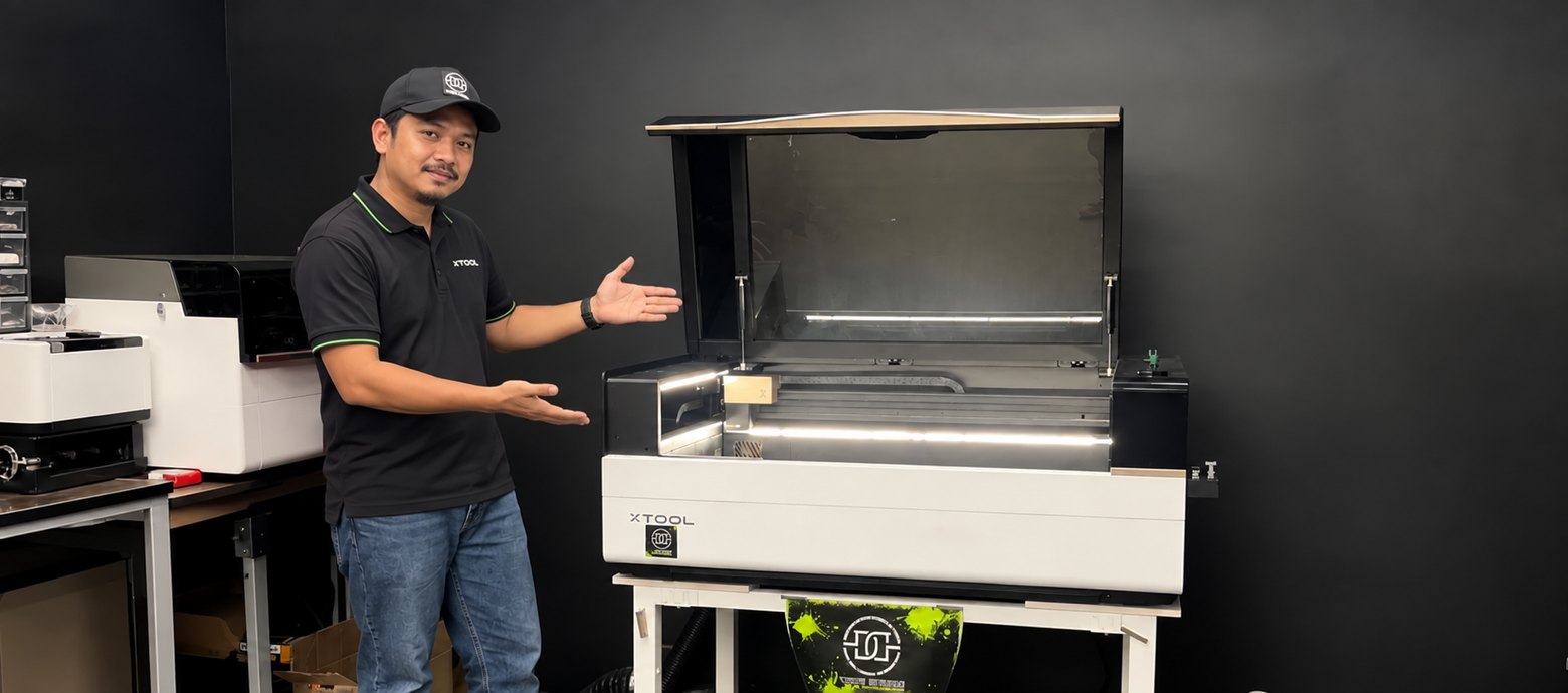 A laser engraving specialist presenting an open xTool CO2 laser cabinet cutter in the workshop